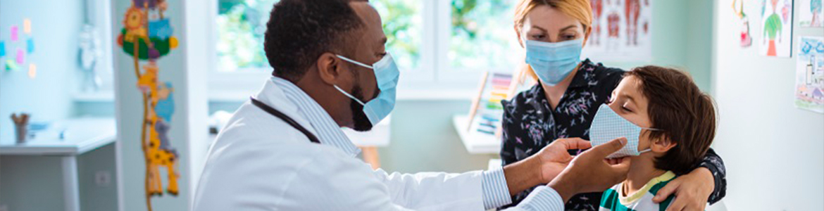 Médico pediatra examinando um garoto acompanhado de sua mãe.