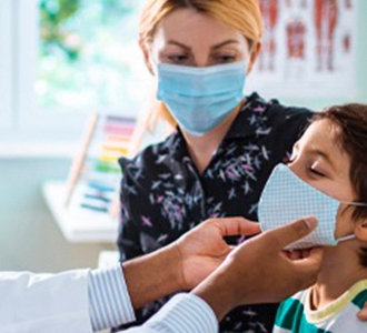 Médico pediatra examinando um garoto acompanhado de sua mãe.